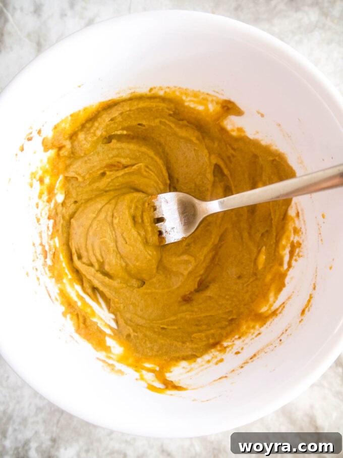 Autumn Spiced Chocolate Pumpkin Dates 7 A bowl containing a creamy mixture of pumpkin puree, sunflower seed butter, and spices.