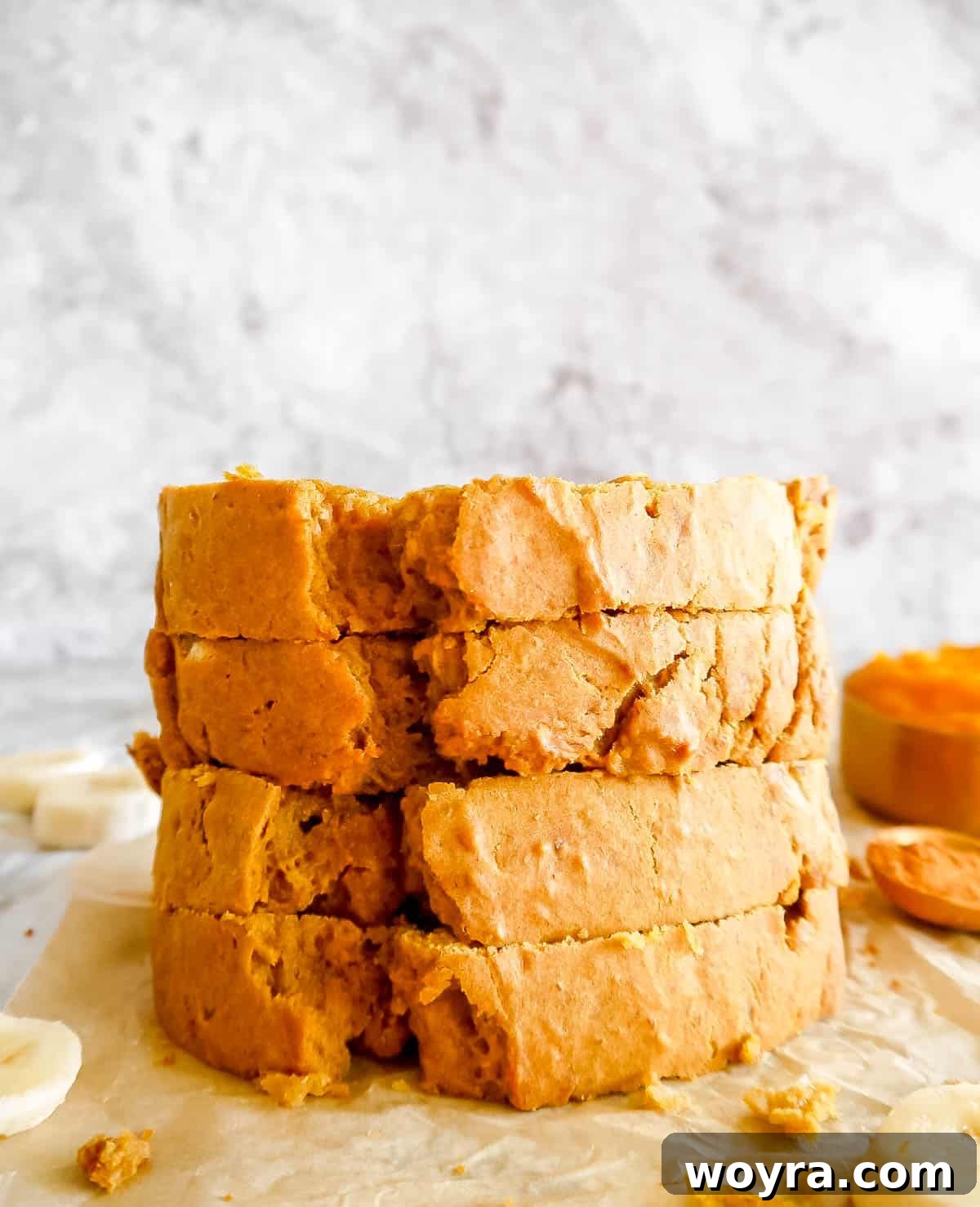 Stacked slices of pumpkin banana bread on a serving plate.