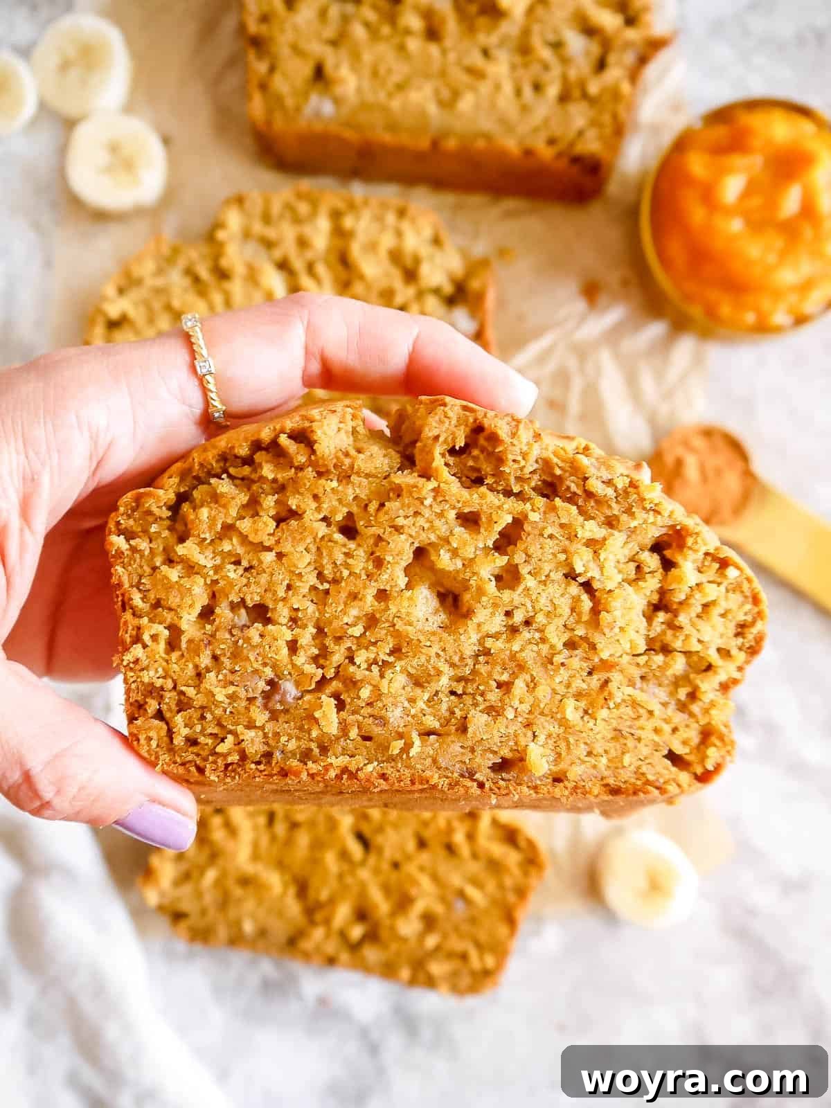 Wholesome Plant-Based Pumpkin Banana Bread 10 Slice of banana pumpkin bread being held in hands, ready to eat.