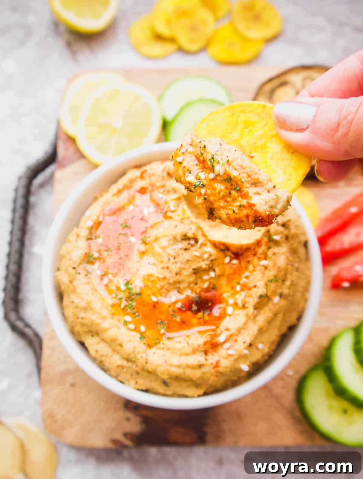 Paleo Mediterranean Cauliflower Dip 7 Mediterranean Cauliflower Hummus with a plantain chip lifting out of it.