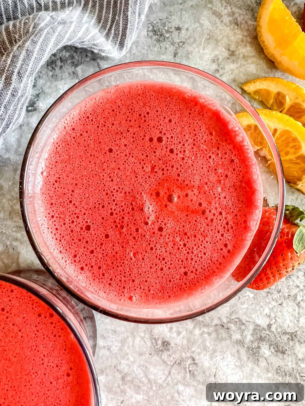 Crimson Garden Elixir 3 Aerial view of freshly prepared beet, carrot, and orange juice in a glass, with ingredients scattered around.