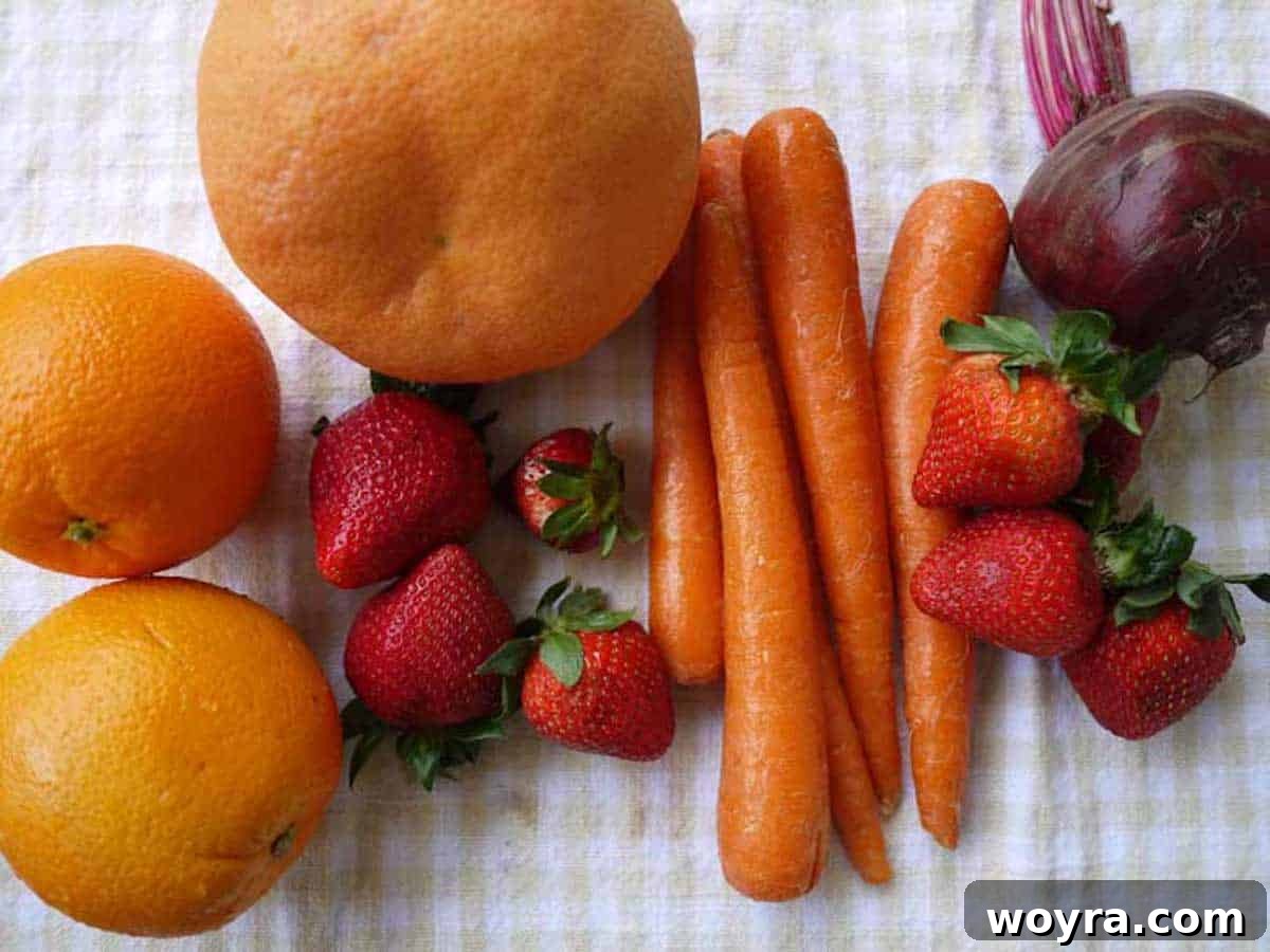 Crimson Garden Elixir 4 Assortment of fresh ingredients including grapefruit, oranges, strawberries, carrots, and beets, ready for juicing.