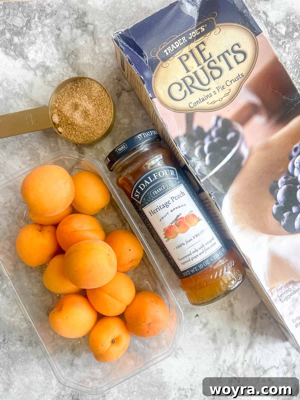 Effortless Apricot Tart 3 Ingredients laid out for making tarte aux abricots: pie crust, jam, rolled oats, fresh apricots, and brown sugar.