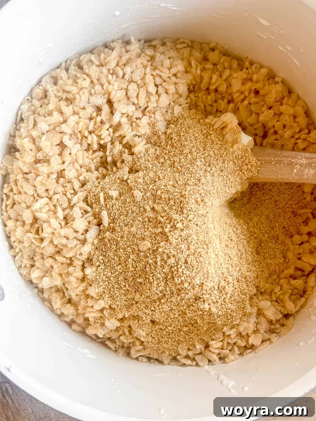 Campfire S'mores Krispie Bars 9 Crispy rice cereal and crushed graham crackers are being added to the warm, melted marshmallow mixture in a large saucepan.