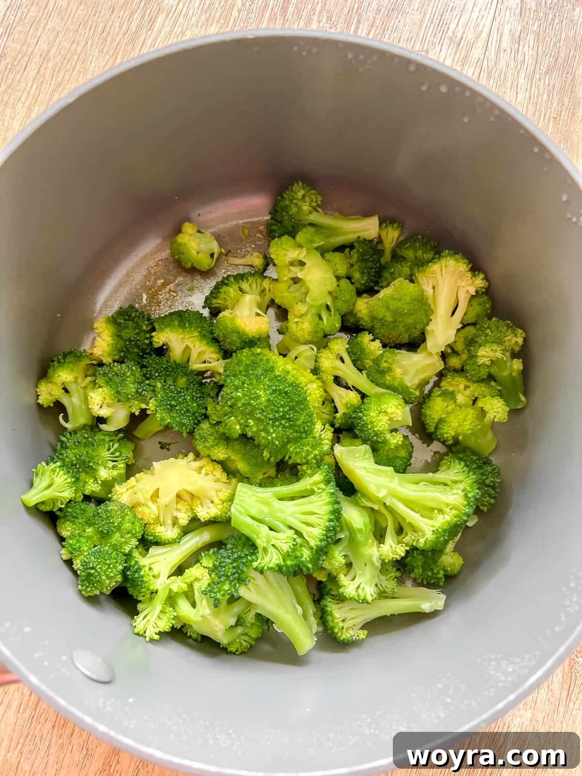 Savory Broccoli Egg Cups 6 Steamed broccoli florets in a covered pan.