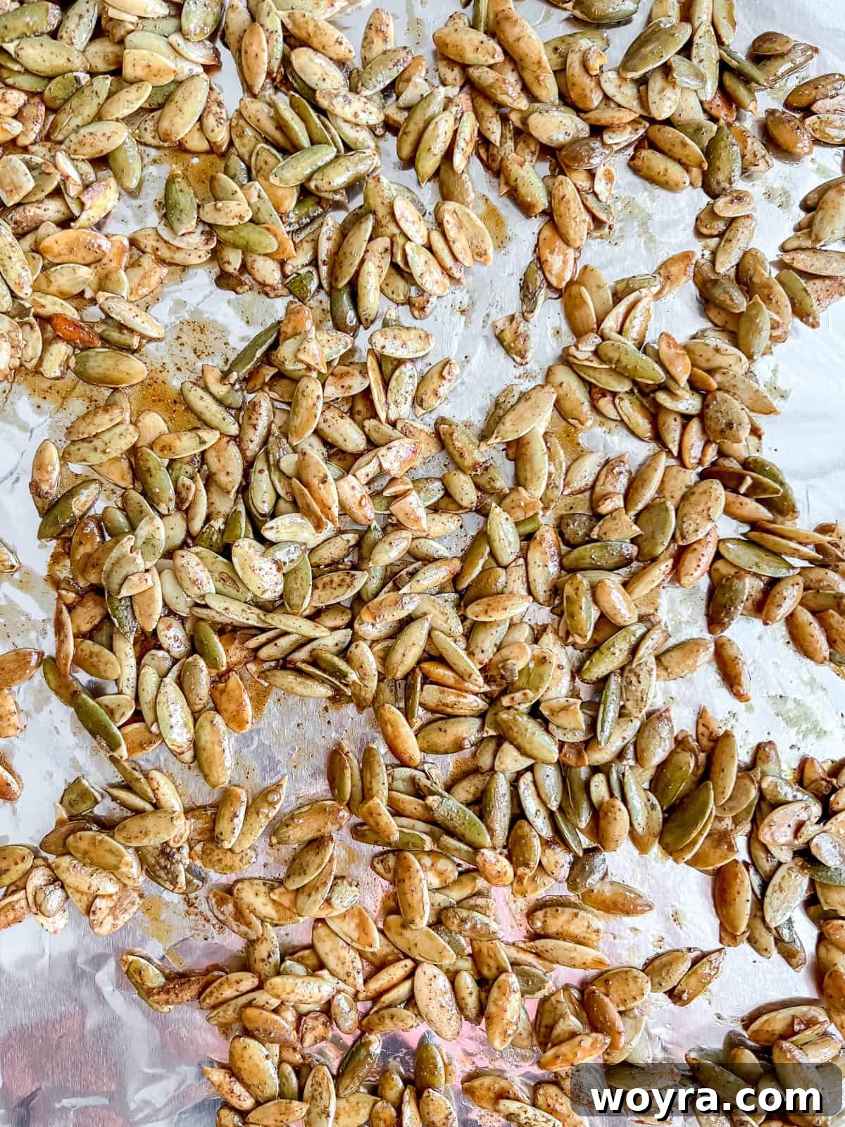 Roasted maple pepitas golden brown and crispy on a cookie sheet, fresh out of the oven.