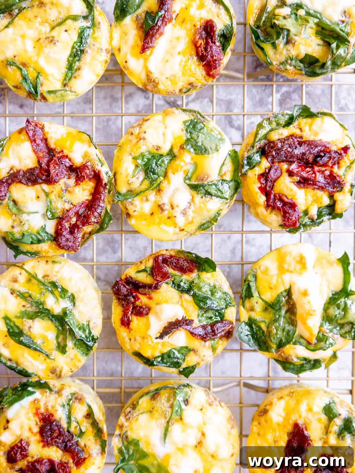 Spinach Feta Egg Bites 3 Close-up of baked spinach feta egg cups in a muffin tin, showing their golden tops.