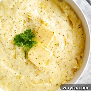 Mashed potatoes cottage cheese in a large bowl with butter on top.