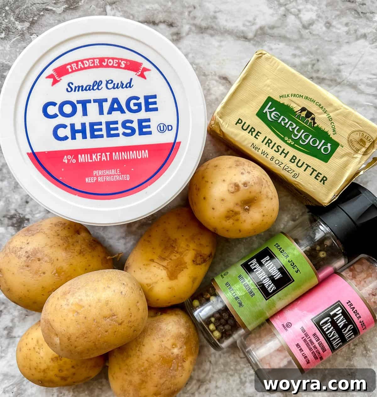 All the ingredients neatly laid out on a counter for making cottage cheese mashed potatoes, including potatoes, cottage cheese, butter, salt, and pepper.