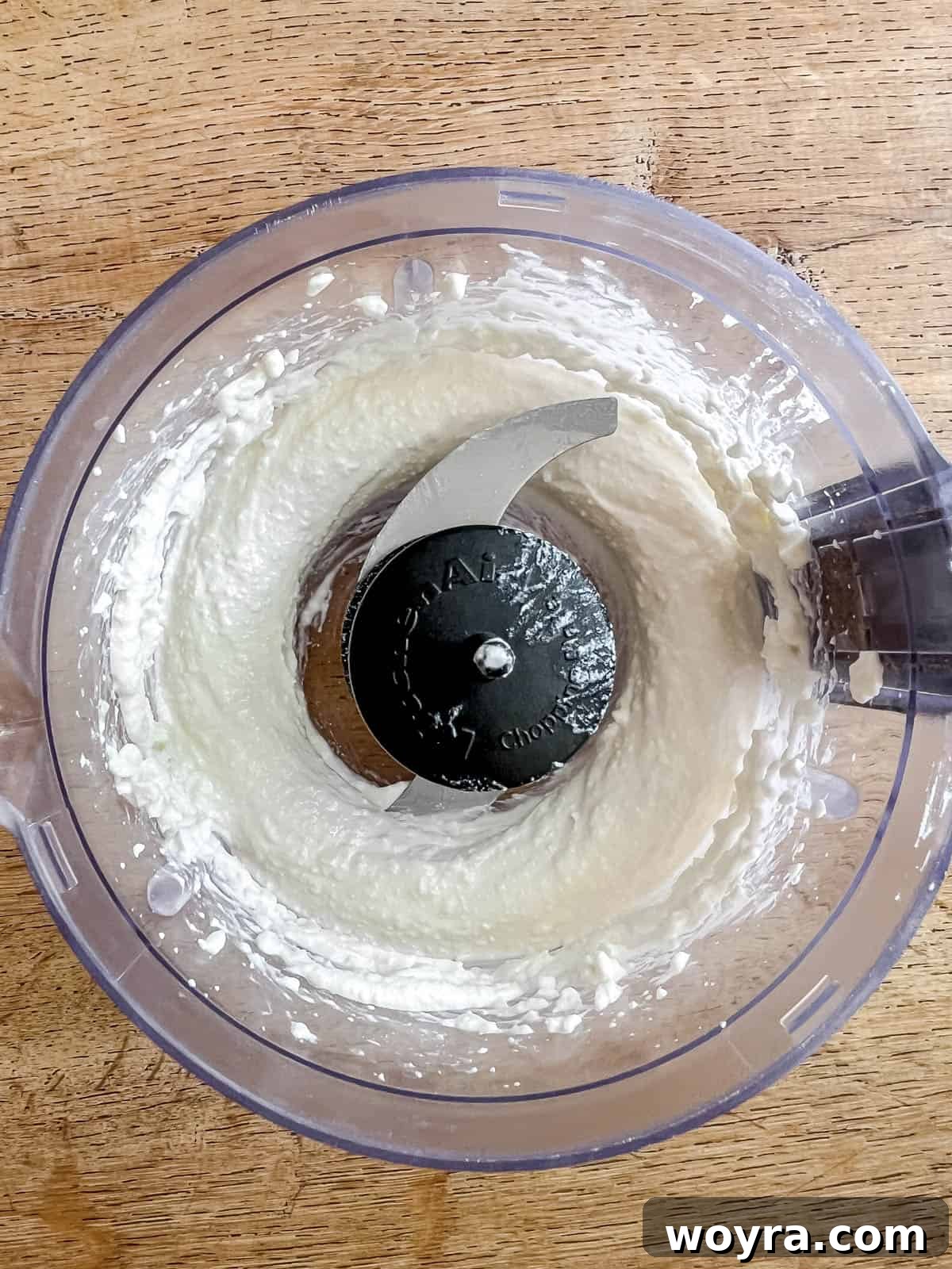 Cottage cheese being whipped until smooth in a food processor.