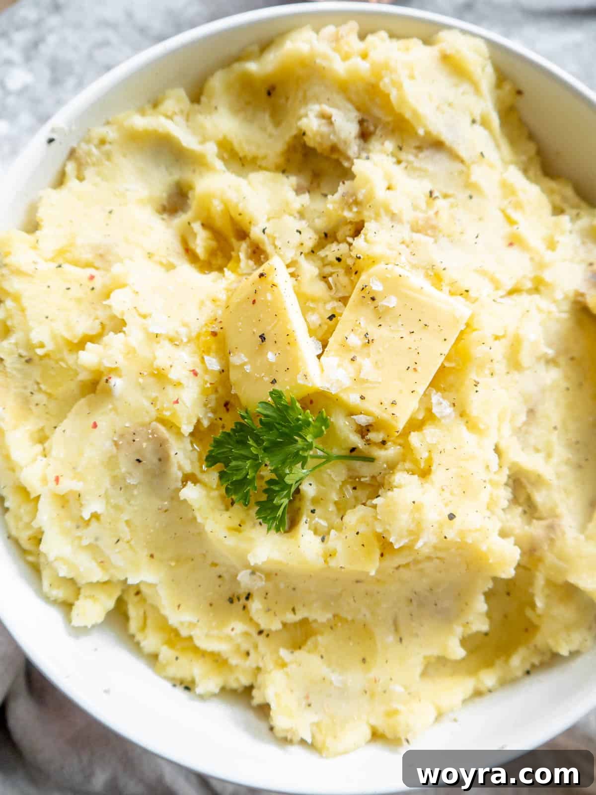 A beautifully presented bowl of creamy cottage cheese mashed potatoes with a pat of butter melting into them, ready to be enjoyed.
