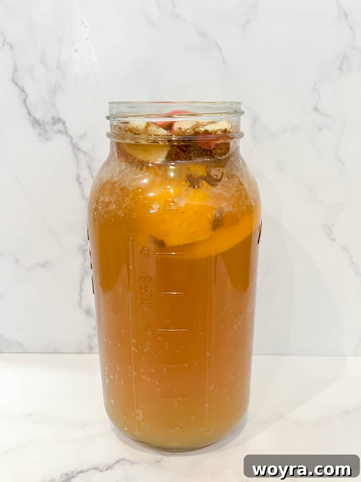 Orchard Ember Elixir 5 The Thanksgiving Punch with alcohol in a pitcher after all ingredients have been added, ready for refrigeration.