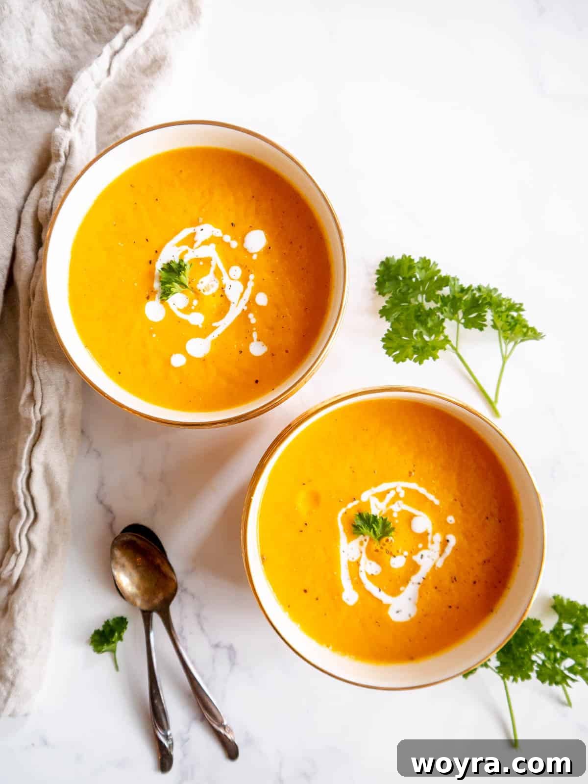 Roasted butternut squash and carrot soup served in two bowls, ready to be enjoyed.