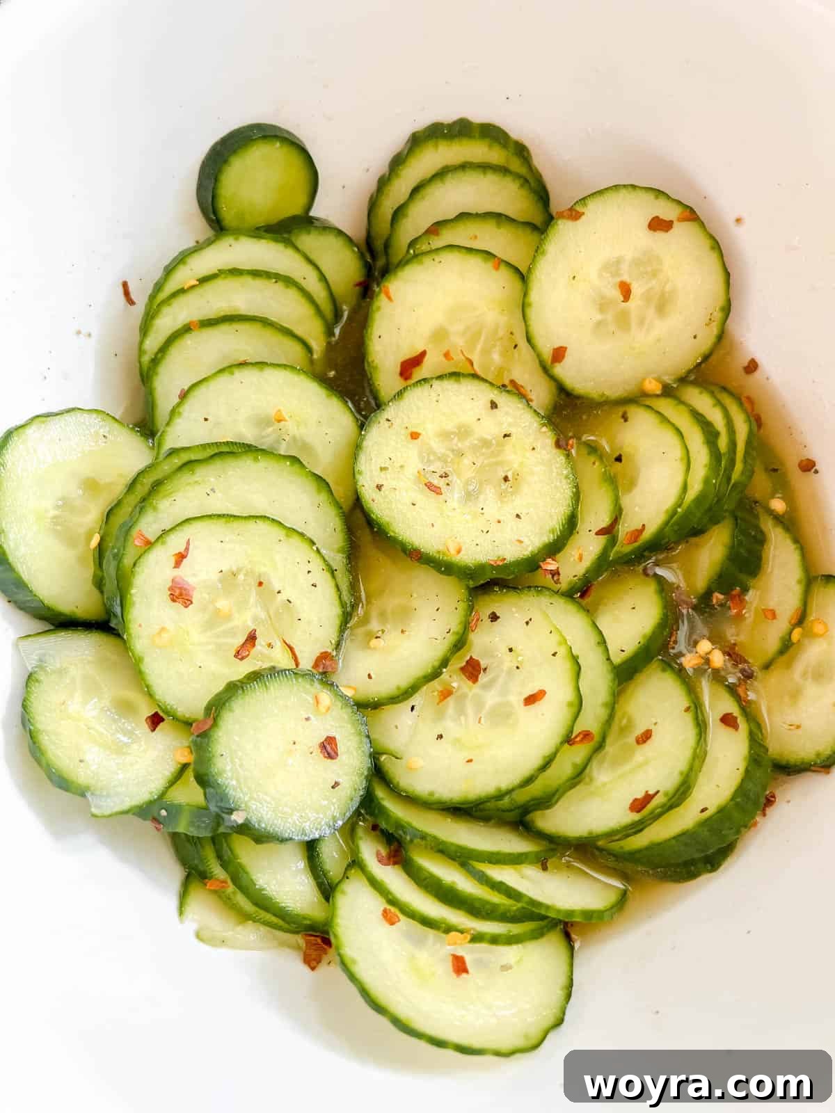 Dynamite Salmon Rice Bowl 6 Quick Asian pickled cucumbers in a bowl, marinating in liquid.