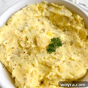 Greek yogurt mashed potatoes in a large bowl with butter melting on top.