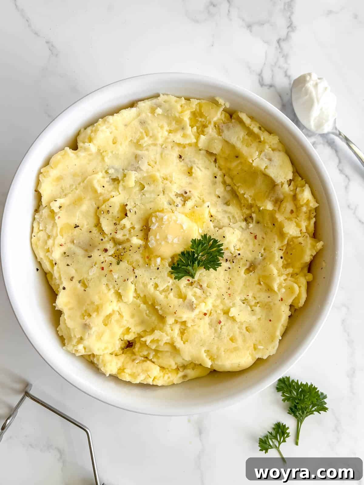 Large bowl of Greek yogurt mashed potatoes, perfectly smooth and garnished.