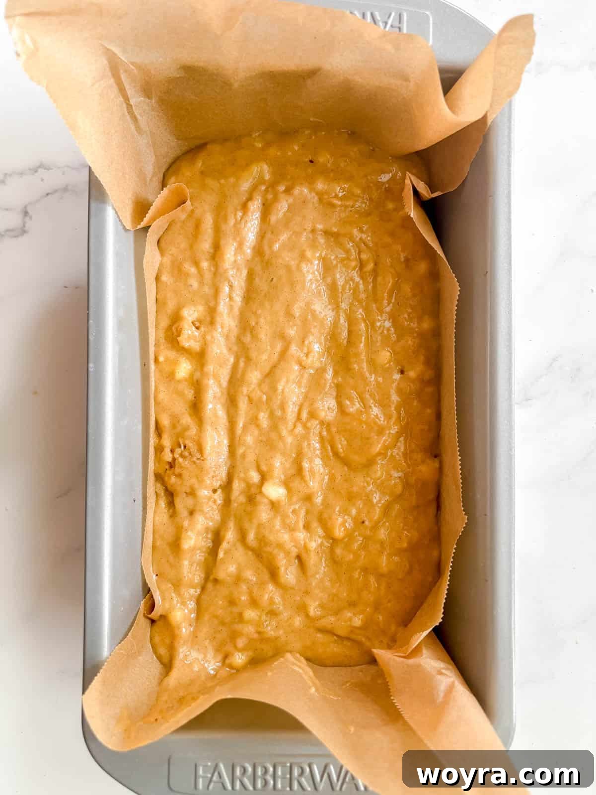 Mediterranean Banana Bread 7 Olive oil banana bread batter poured into a greased and parchment-lined loaf tin, ready for baking.