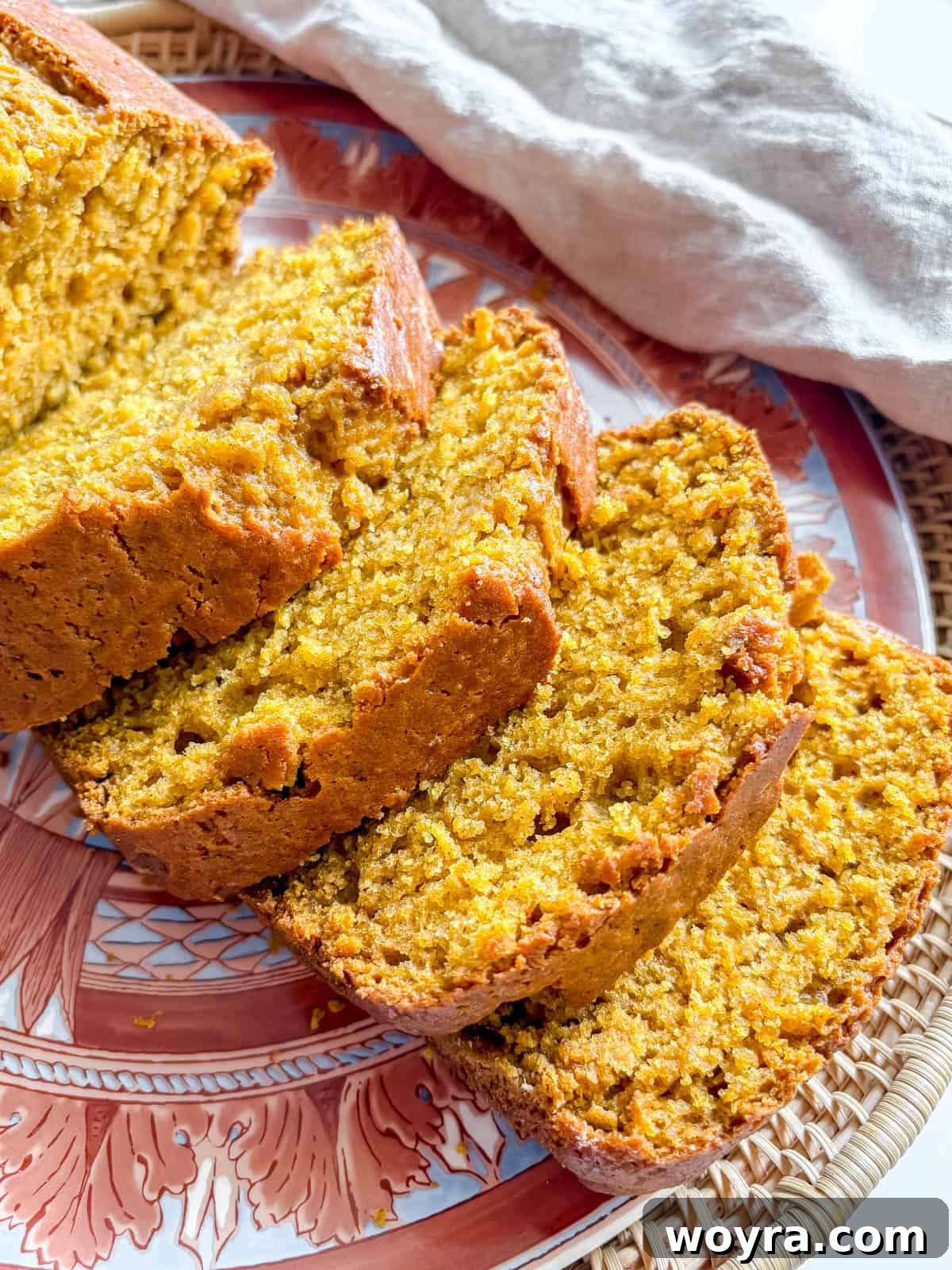 Close-up of moist slices of pumpkin bread on a plate, showcasing its tender texture.