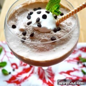 Dairy-free frozen hot chocolate with whipped cream and chocolate garnish in a tall glass.