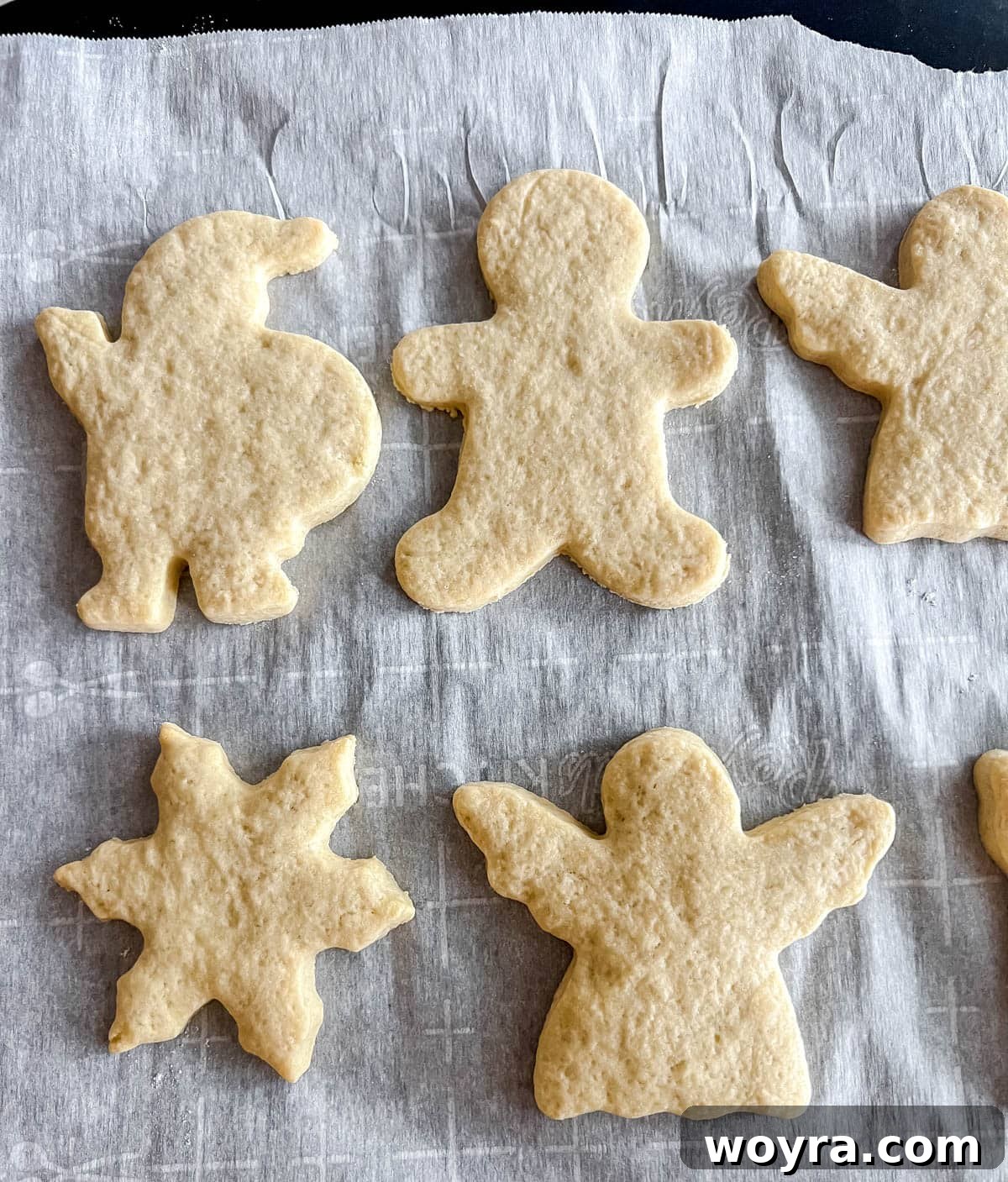 Artfully Shaped Sable Cookies 13 Sable cut out sugar cookies on a baking sheet after baking, lightly golden.