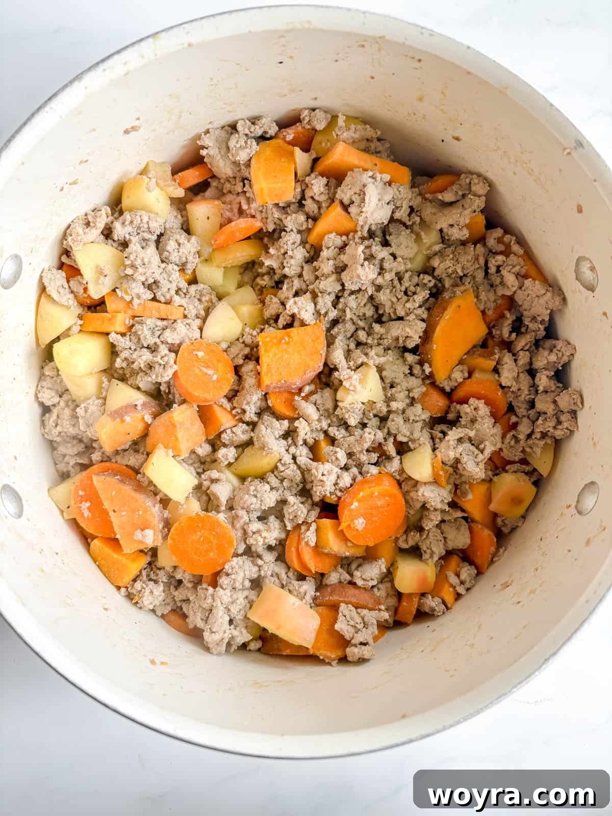 Orchard Spice Turkey Chili 5 Ground turkey being added to the pot with the cooked vegetables and apples, ready to be browned.