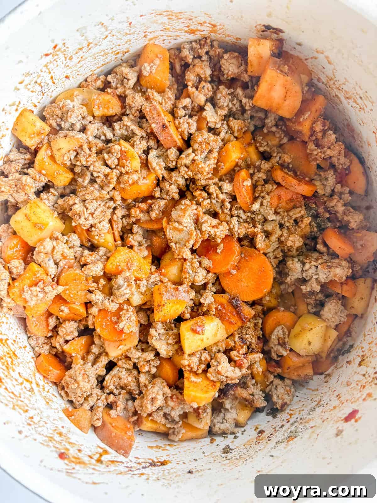 Orchard Spice Turkey Chili 6 Tomato paste being stirred into the browned ground turkey and vegetable mixture.