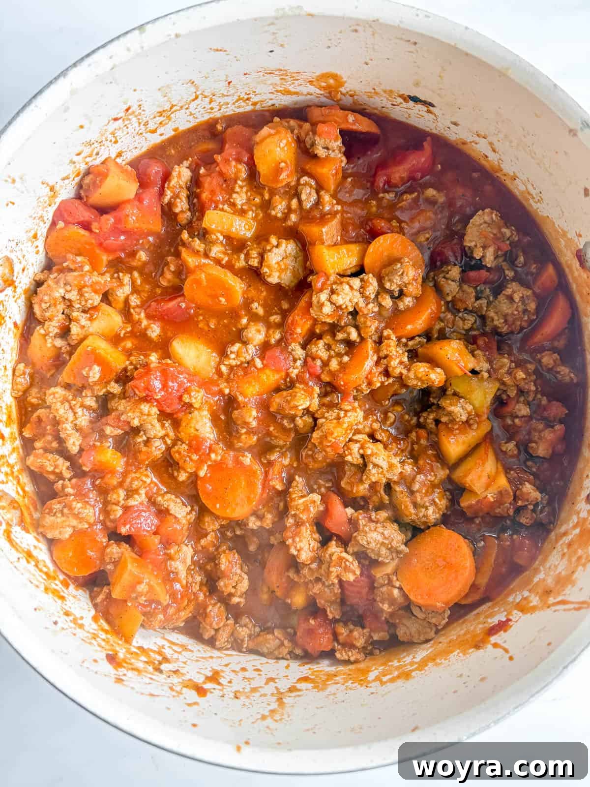 Orchard Spice Turkey Chili 7 Crushed and strained tomatoes poured into the pot, forming the base of the chili.