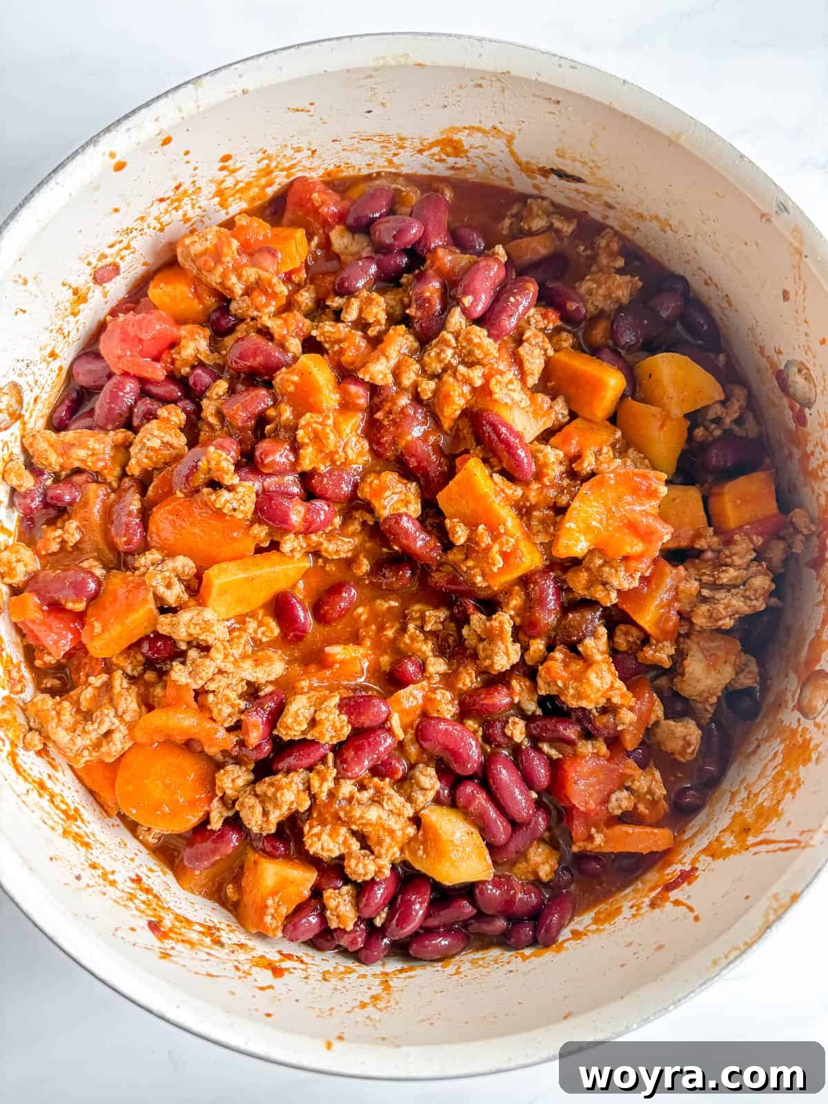Orchard Spice Turkey Chili 8 Cans of kidney beans being added to the simmering turkey apple chili.