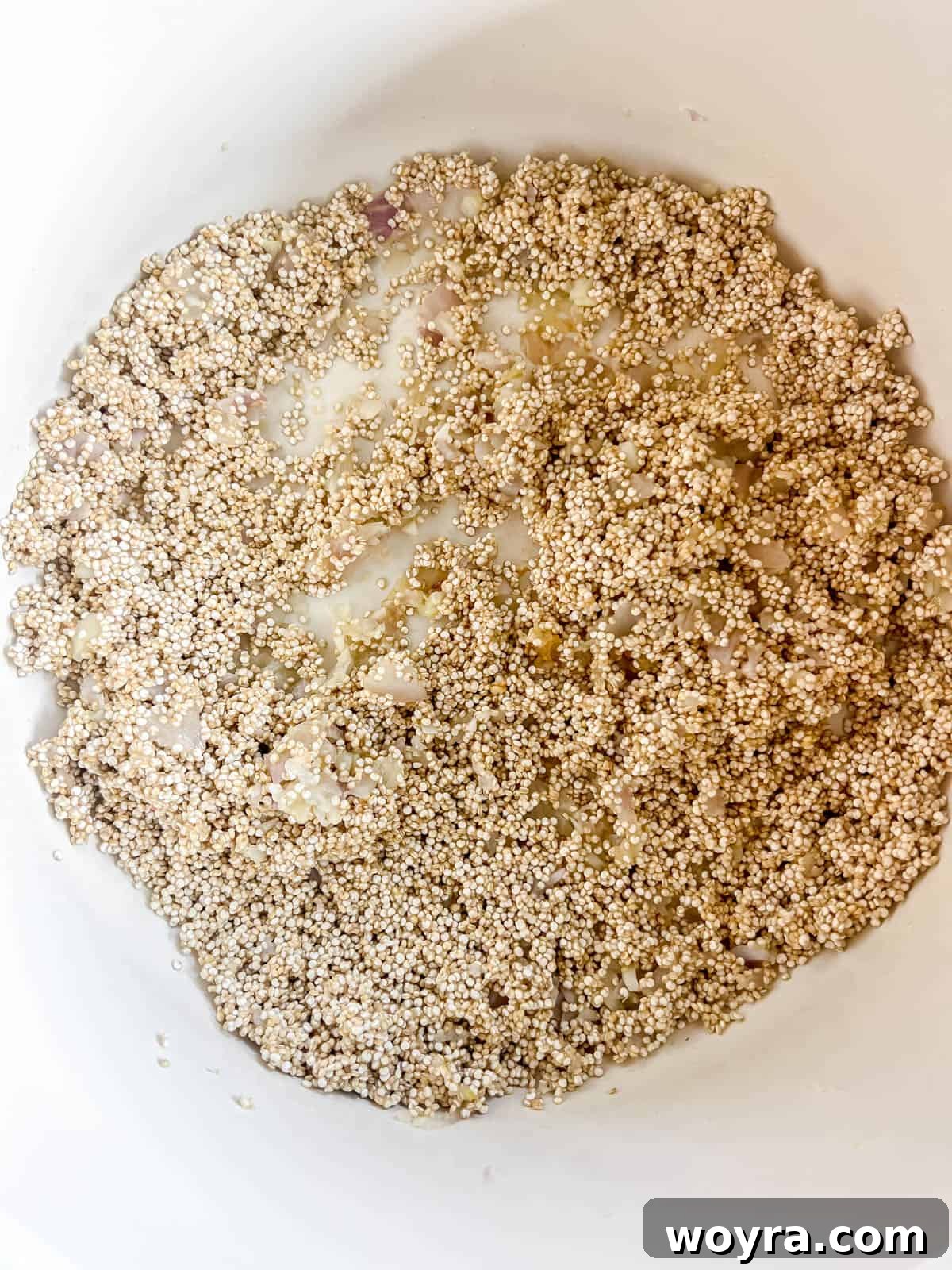 A splash of milk being poured into the pan with the quinoa mixture, to add initial creaminess.