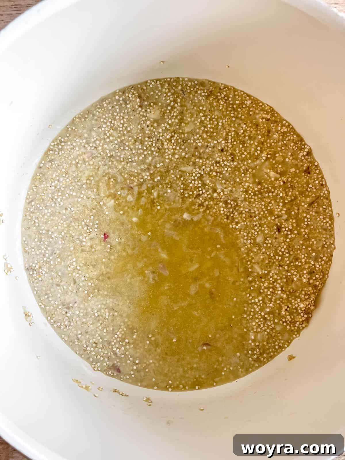 Velvety Mushroom Quinoa Risotto 8 A ladle of chicken stock being added to the quinoa in the pan, marking the beginning of the slow absorption process.