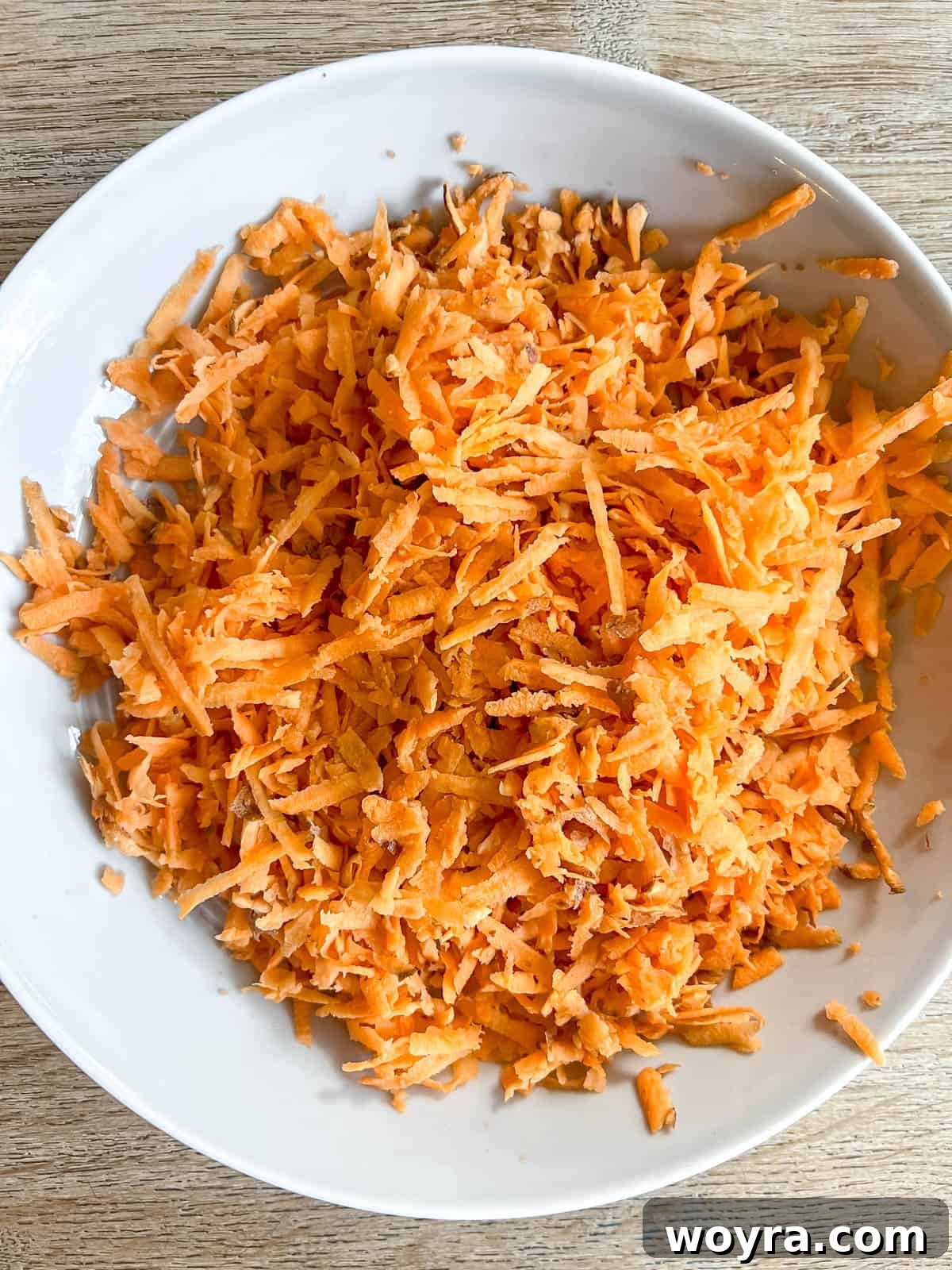 Sweet Potato Bacon Breakfast Nests 4 Freshly shredded sweet potato in a mixing bowl, ready for the egg cup recipe.