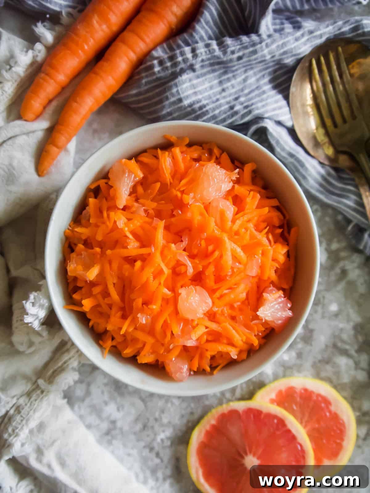 Tangy Citrus Carrot Crunch 3 Close-up aerial view of freshly shredded carrots in a bowl, ready for mixing.