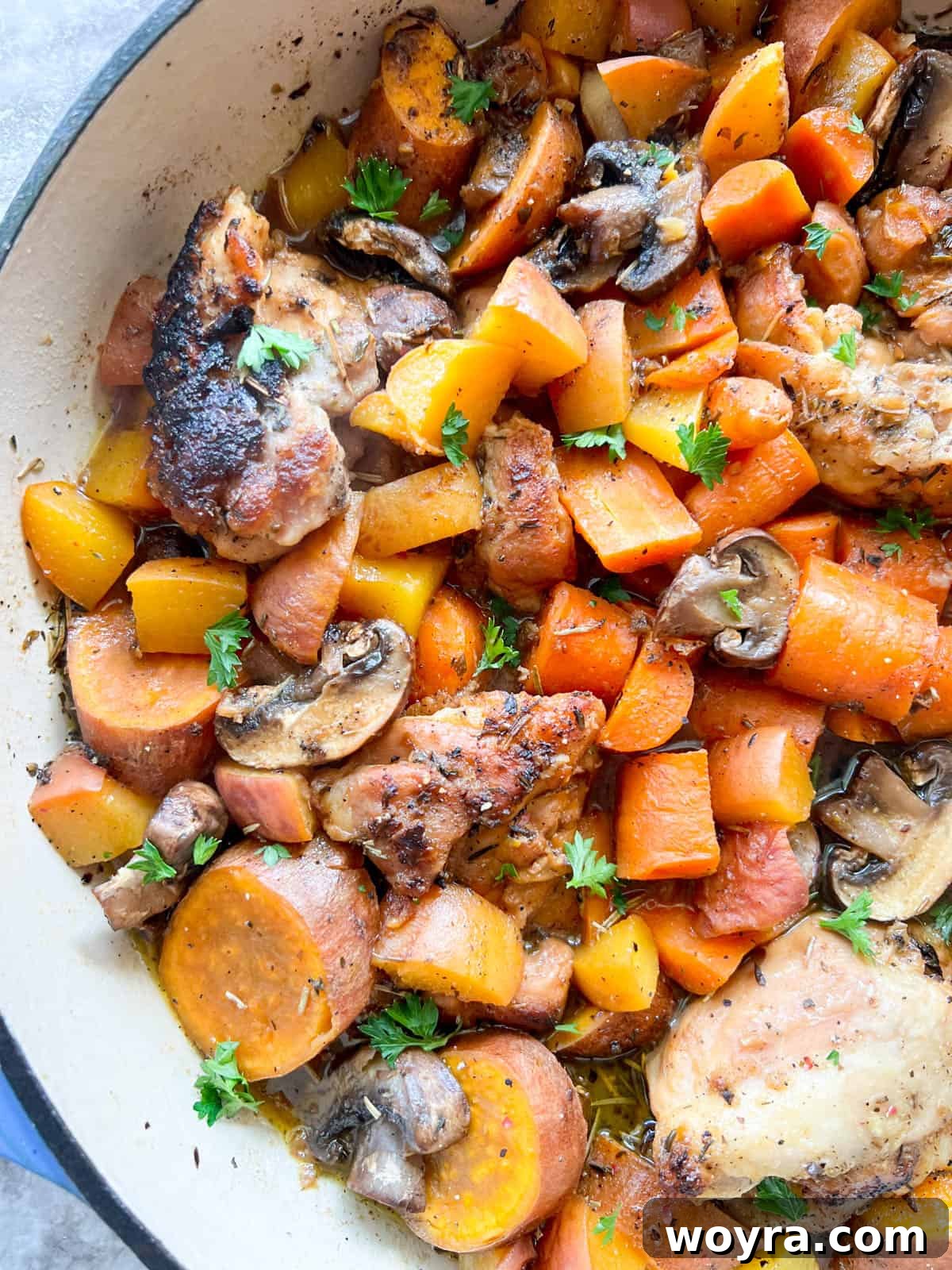 The fully cooked Maple Peach Chicken Thighs in the Dutch oven, garnished and ready to be served.