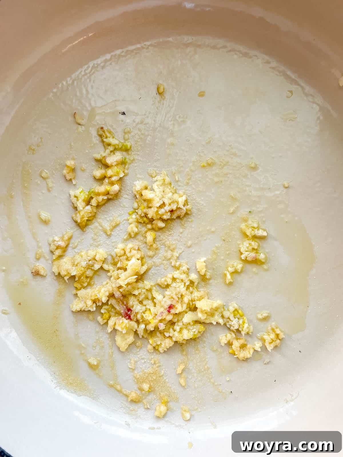Minced garlic and onion sizzling in olive oil in a heated Dutch oven.