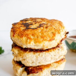 Three healthy chicken burger patties stacked on top of each other, ready to be enjoyed.