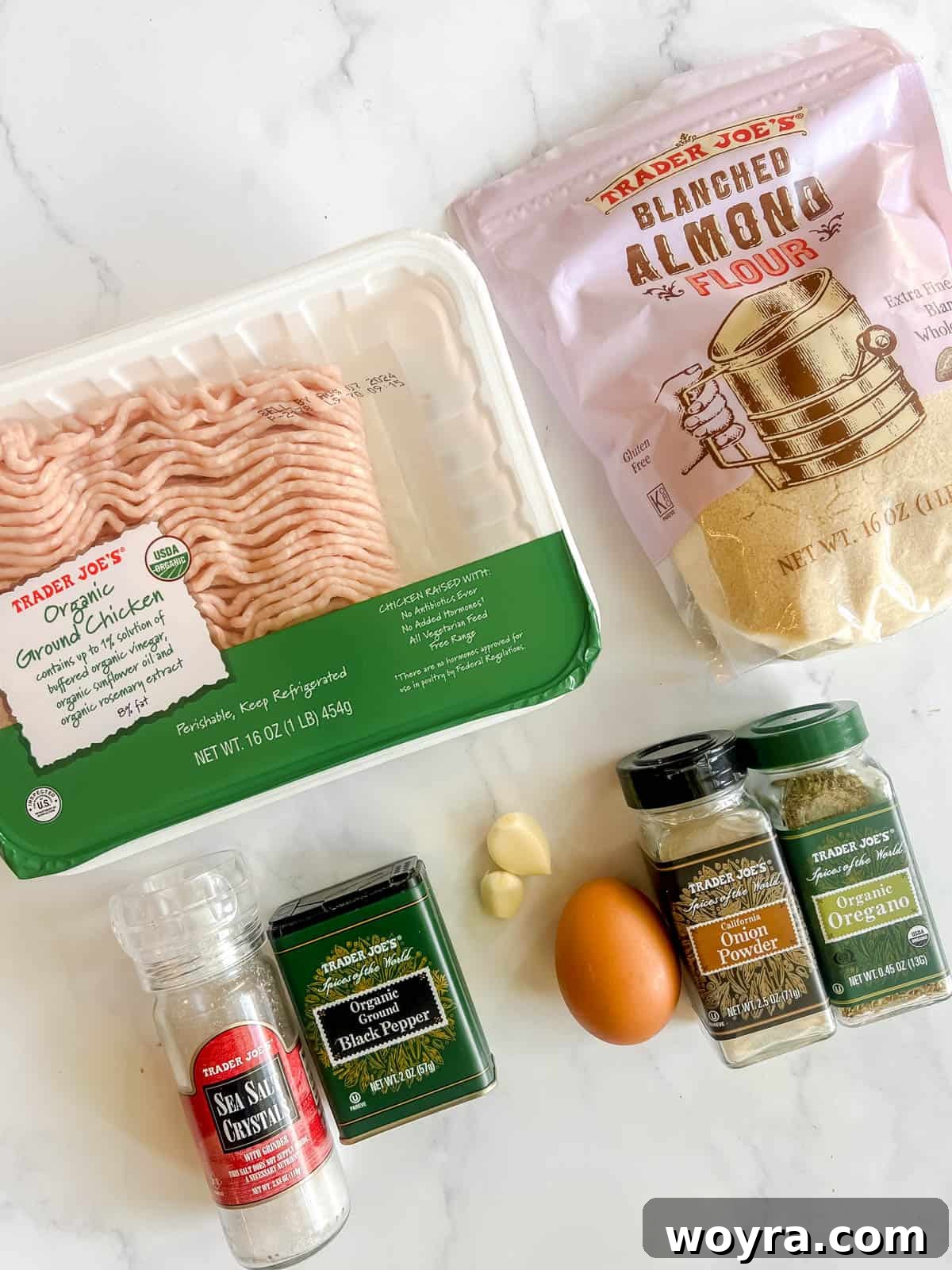 All the raw ingredients for making healthy chicken burgers laid out on a kitchen counter.