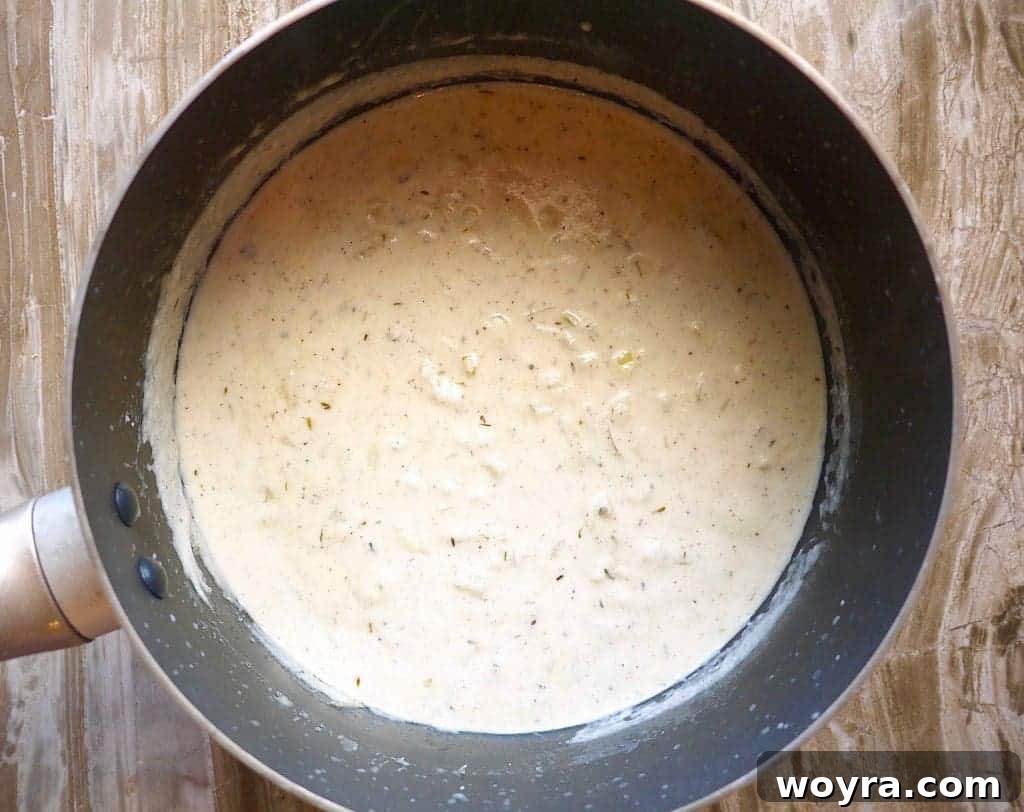 Paleo Friendly Squash Au Gratin 5 Creamy Paleo sauce for squash au gratin cooking in a pan.
