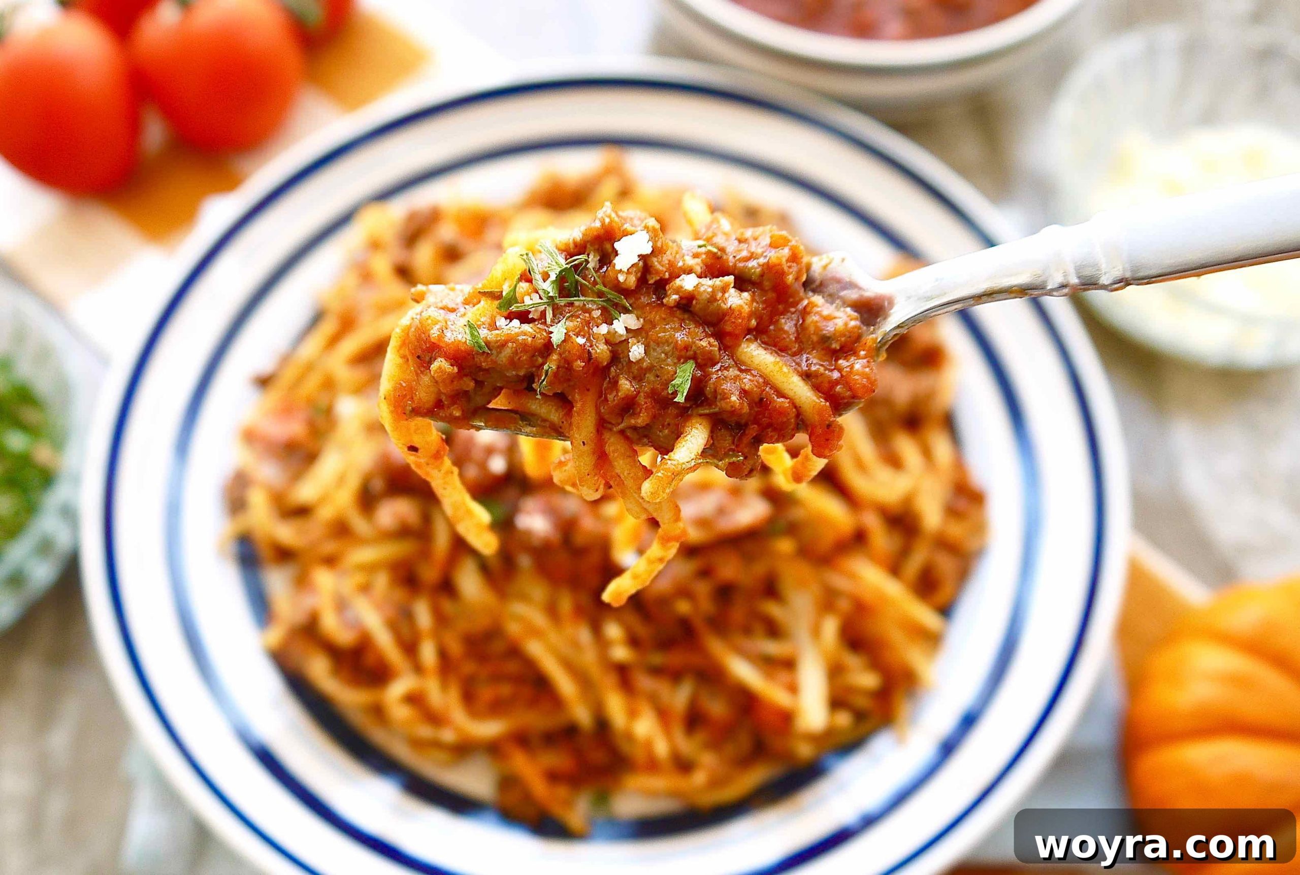 Golden Pumpkin Ragu 5 A fork holding a perfect bite of rich pumpkin ragu with flecks of herbs and meat.