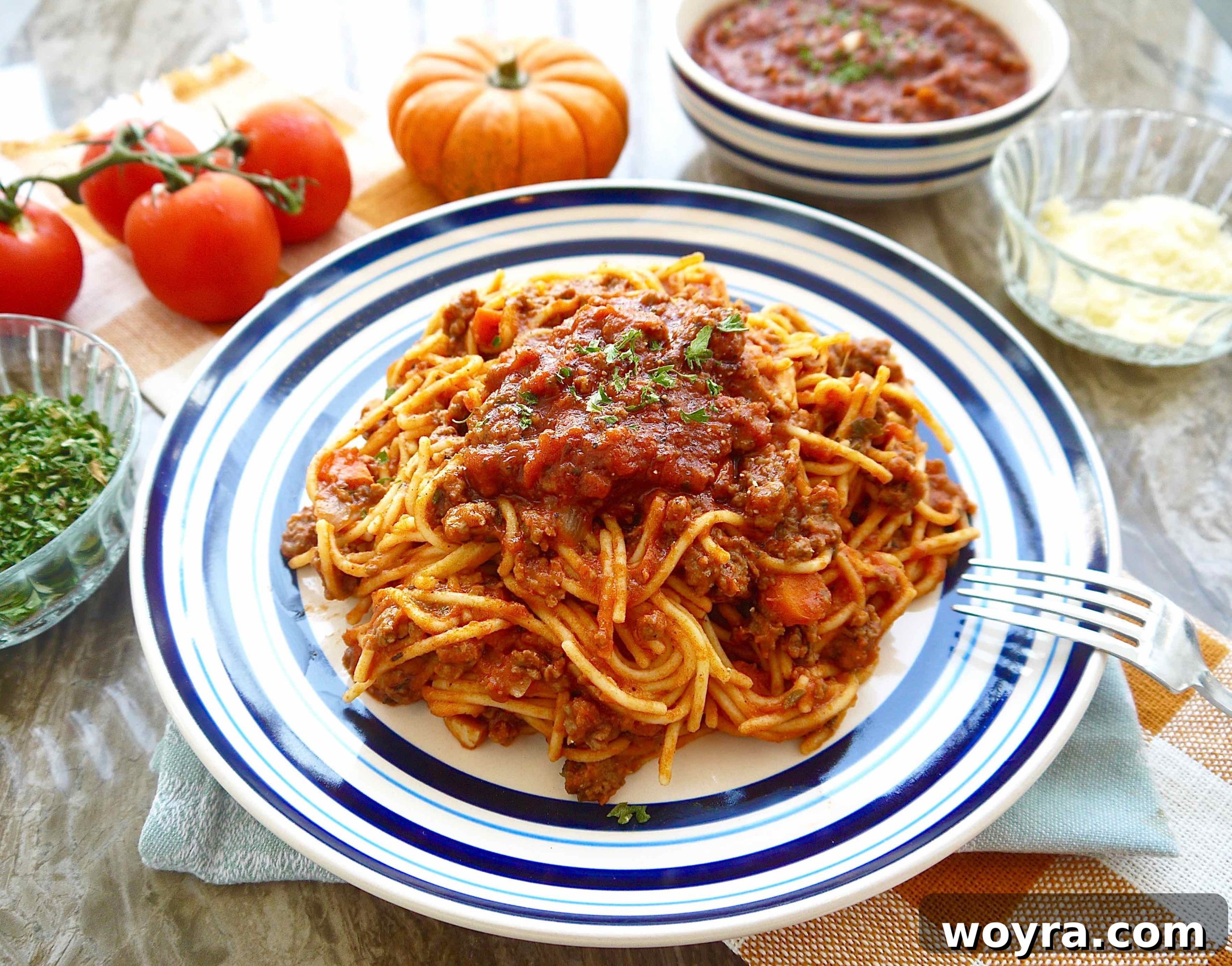 Autumn Pumpkin Ragu 6 Close-up of the rich pumpkin tomato sauce with ground beef on a plate, garnished lightly.