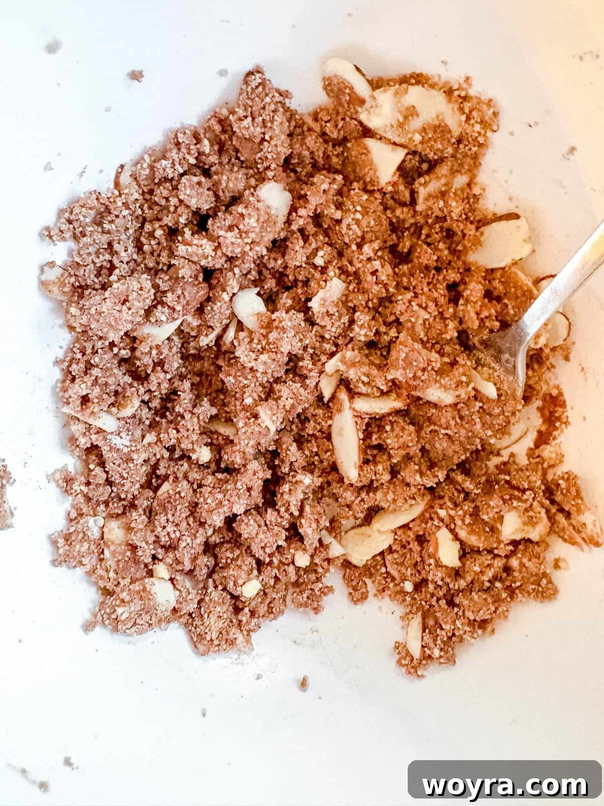 Rustic Chestnut Flour Coffee Cake 7 A bowl containing the crumb topping mixture for chestnut flour coffee cake, showing crushed chestnuts and spices.