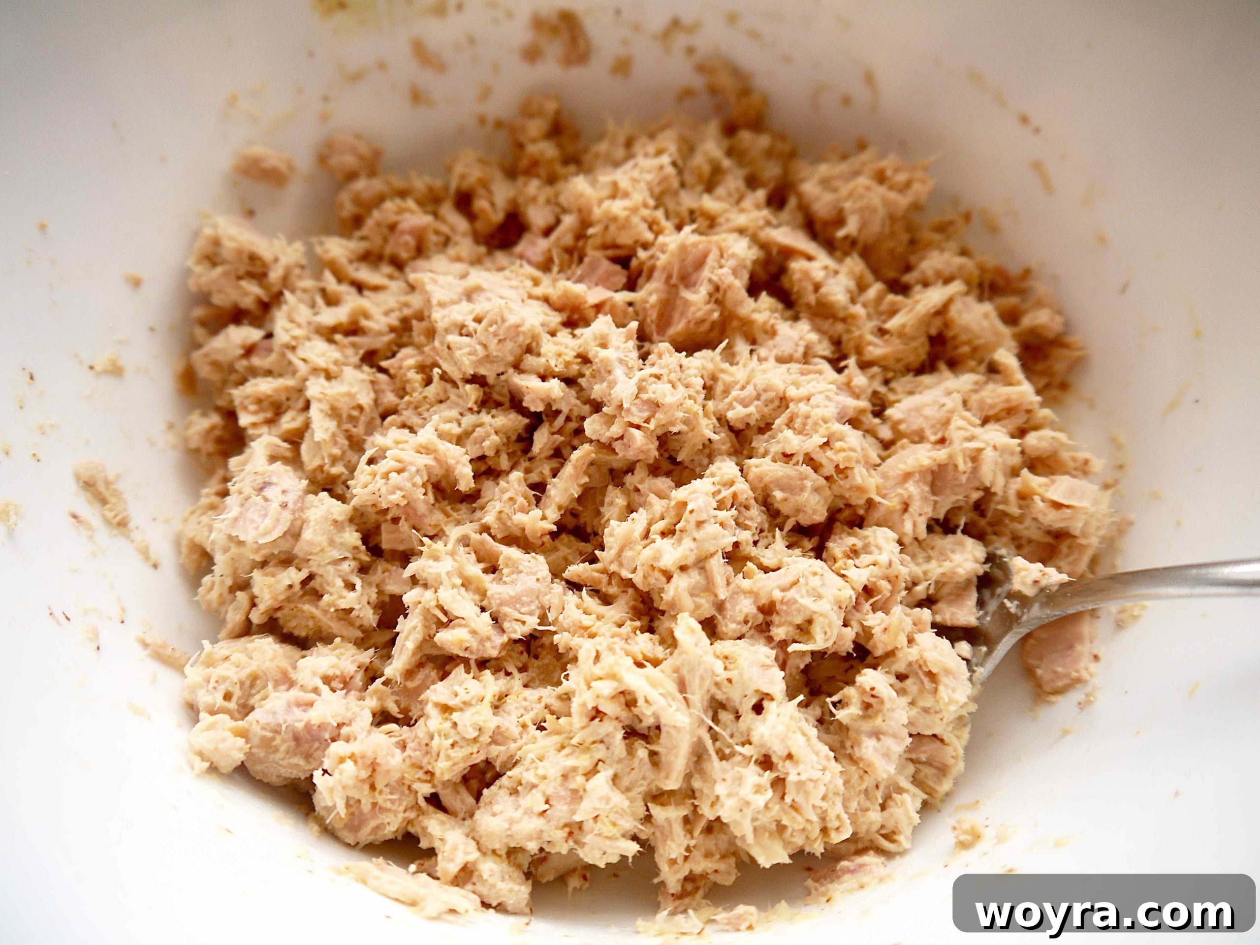 Vibrant Quinoa Beet Tuna Salad 6 Flaked canned tuna being mixed thoroughly with mayonnaise and Dijon mustard in a large mixing bowl.