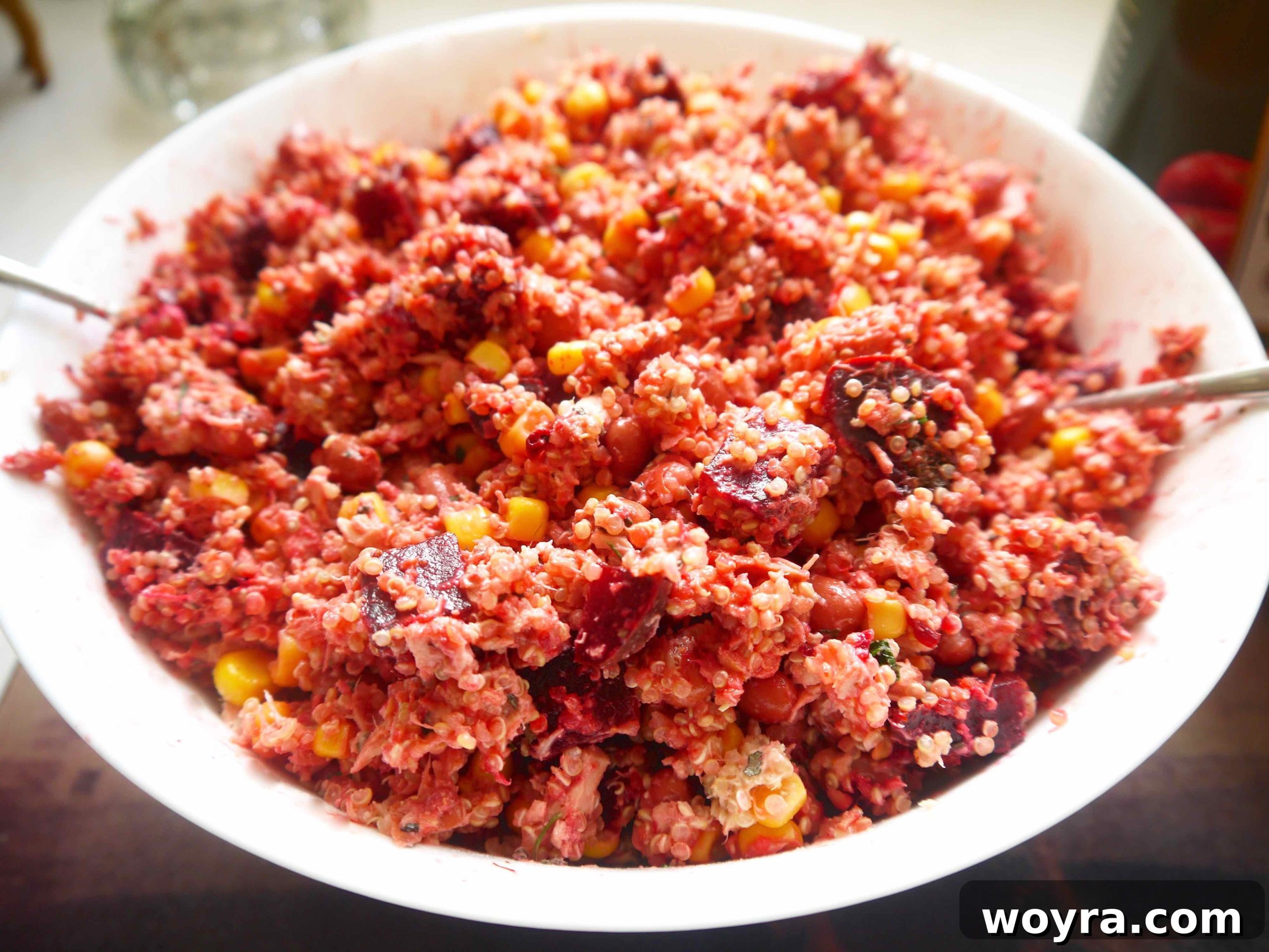 Vibrant Quinoa Beet Tuna Salad 7 All the prepared salad components, including cooked quinoa, corn, kidney beans, and diced beets, being gently mixed into the tuna base in a large bowl.