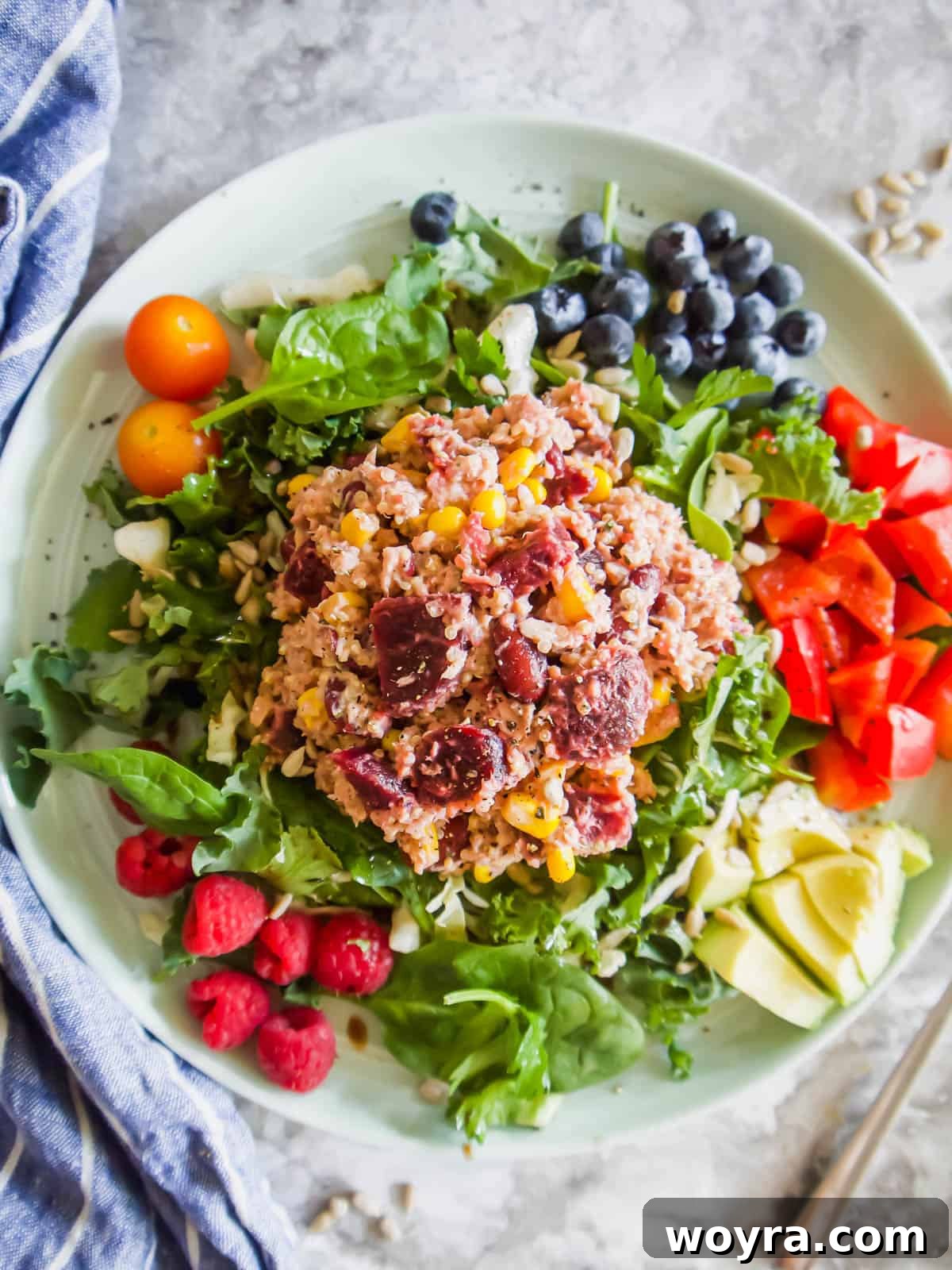 Vibrant Quinoa Beet Tuna Salad 8 A beautifully presented Quinoa Beet Salad with Tuna, garnished with fresh dill, served alongside a side of vibrant fresh fruit and a glass of refreshing beverage.
