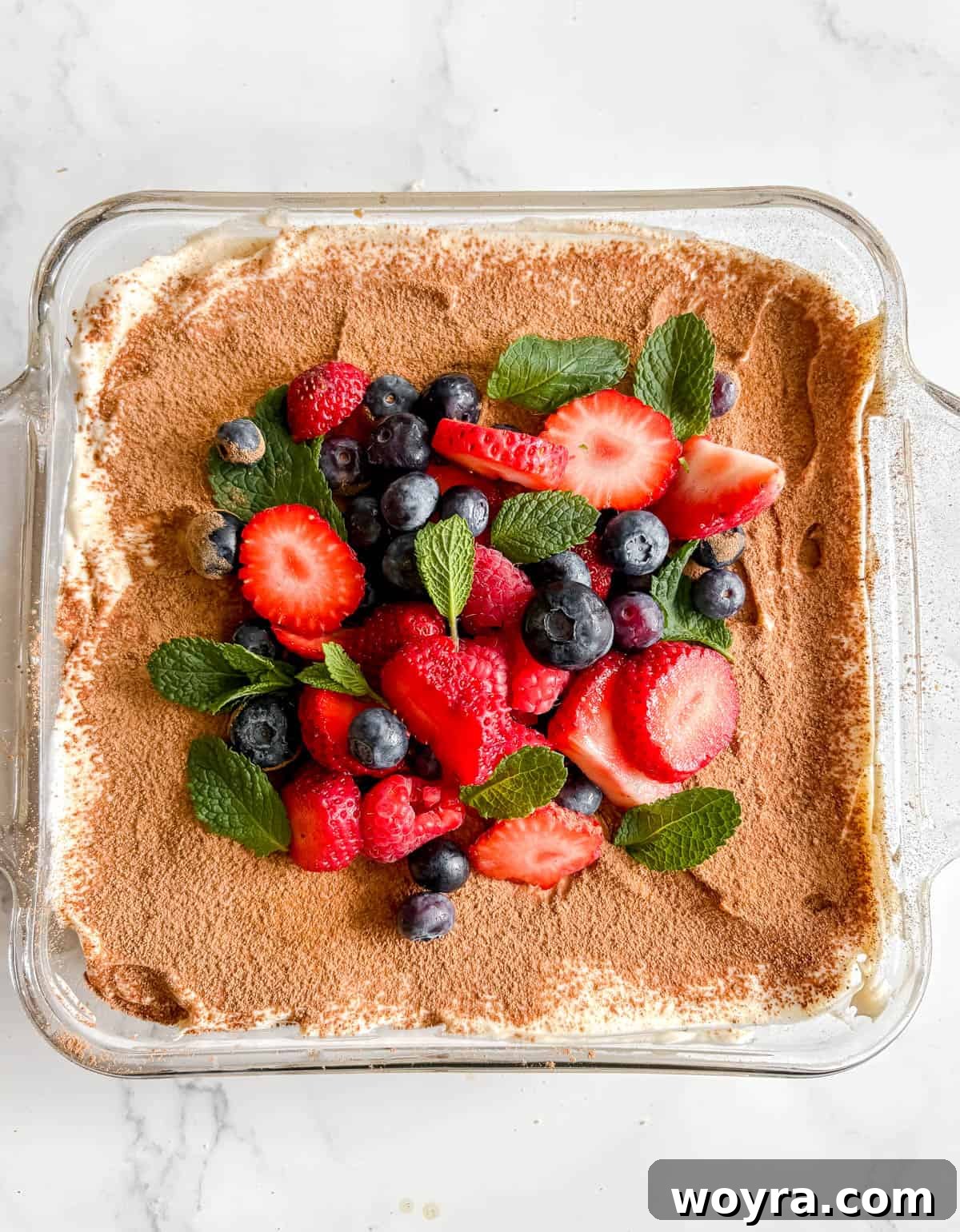 Tropical Coconut Tiramisu 13 Coconut Cream Tiramisu topped with fresh berries and mint leaves.