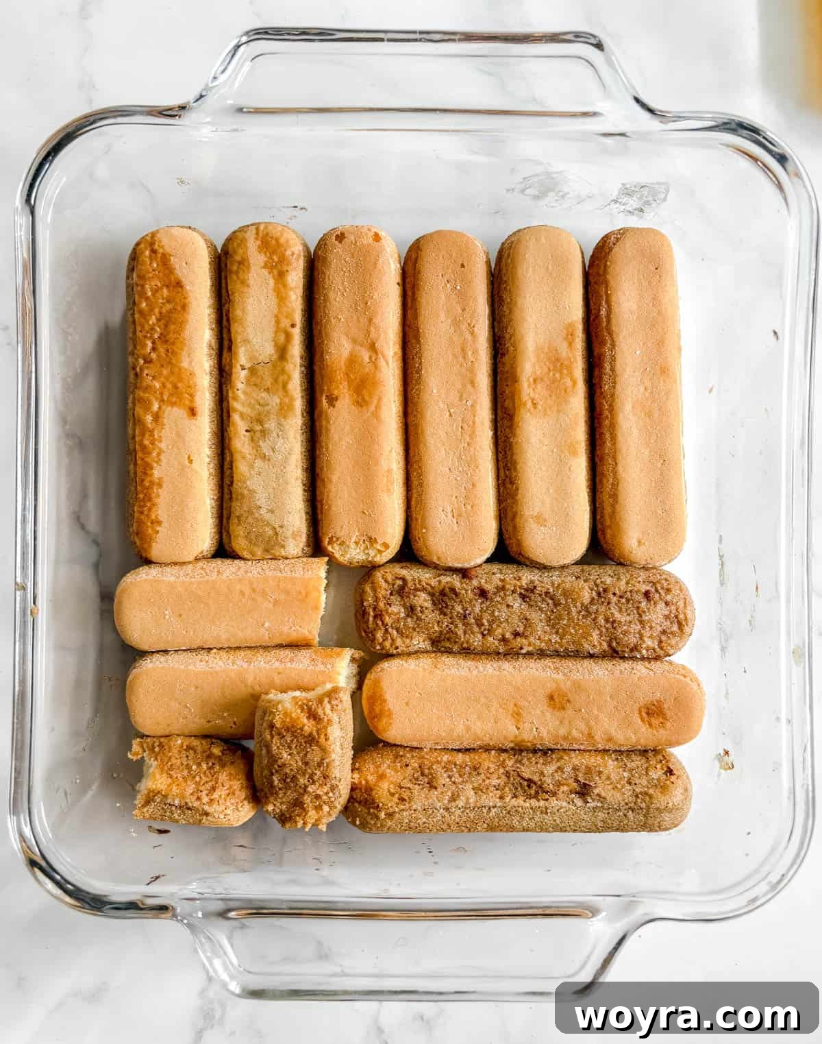 Tropical Coconut Tiramisu 8 First layer of coffee-soaked ladyfingers neatly arranged in a baking dish.