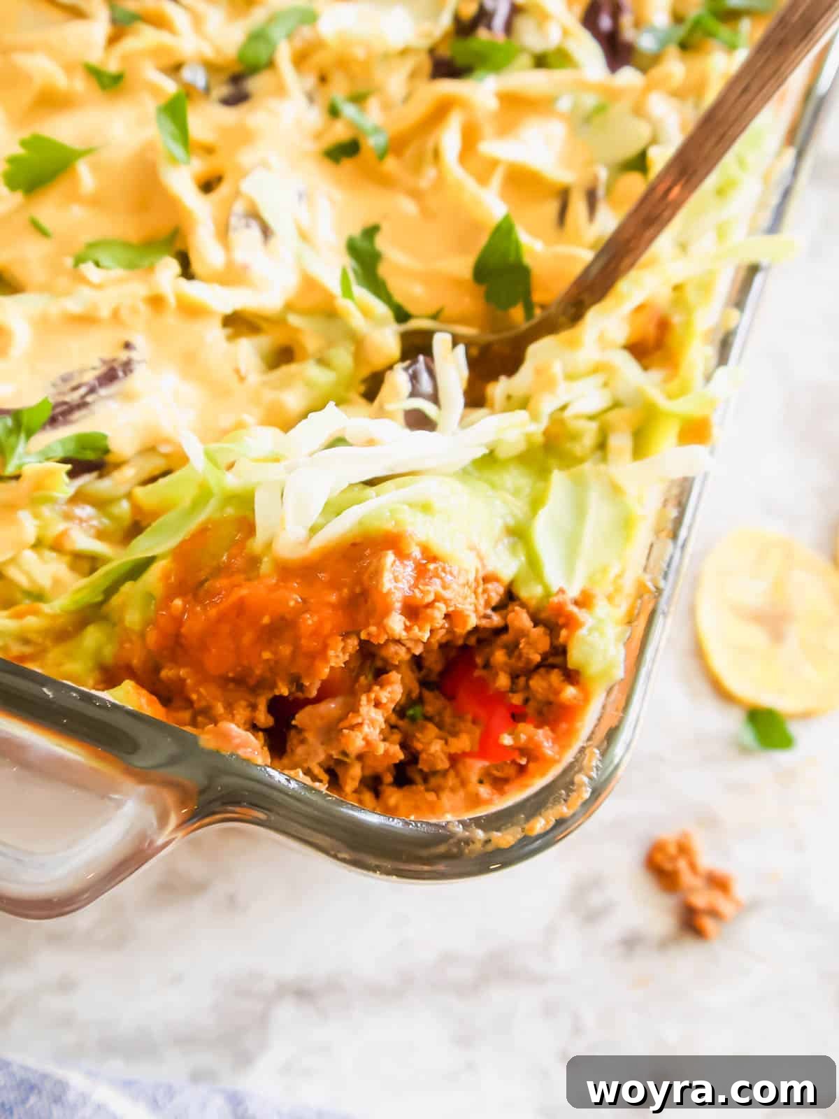 Ultimate Dairy-Free 7 Layer Turkey Taco Dip 13 Dairy free 7 layer dip with a spoon scooping some out, highlighting the delicious layers.