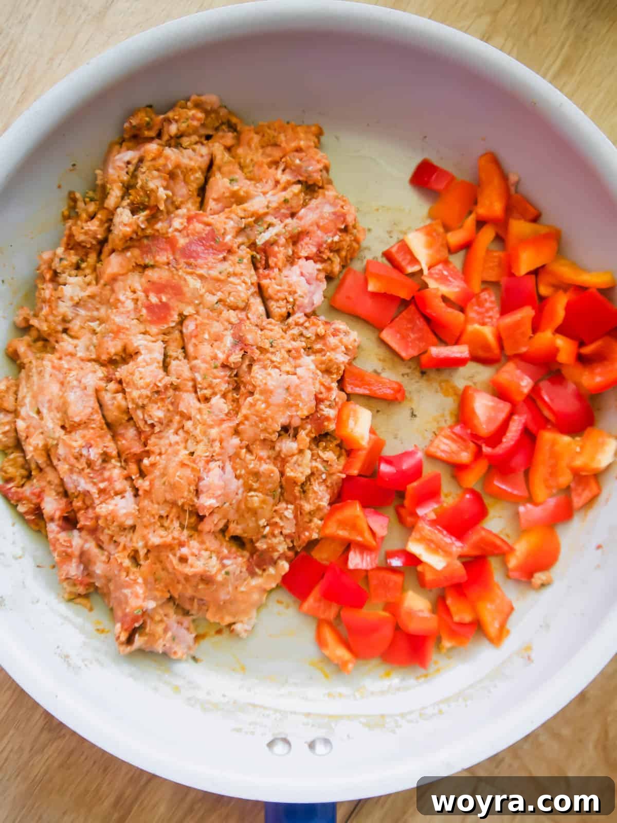 Ultimate Dairy-Free 7 Layer Turkey Taco Dip 5 Ground turkey in a pan with added tomato paste, hot sauce, and diced red bell peppers.