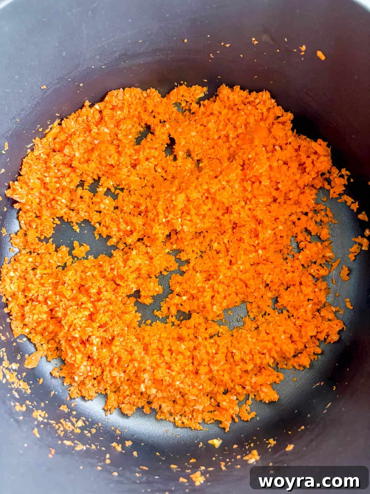Meaty Slow Cooker Spaghetti Sauce 5 Sauteeing garlic and carrots in a pan with olive oil.