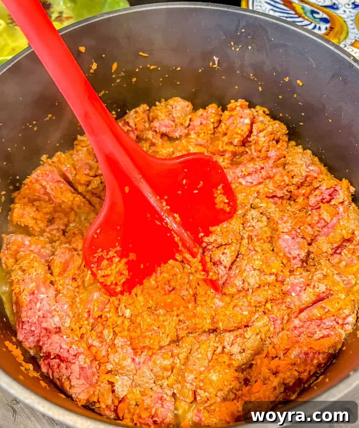 Meaty Slow Cooker Spaghetti Sauce 6 Using a meat masher to break up ground beef in a skillet.