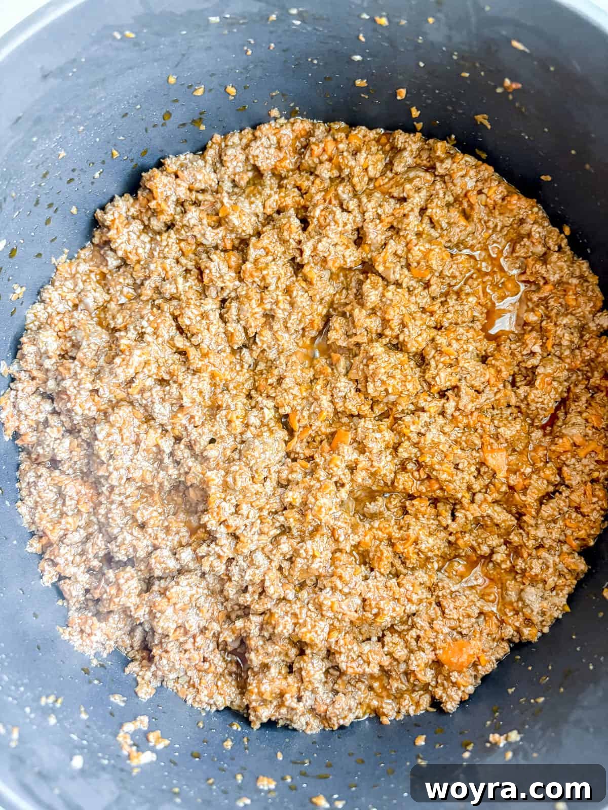 Meaty Slow Cooker Spaghetti Sauce 7 Browned ground beef mixed with tomato paste in a pan.